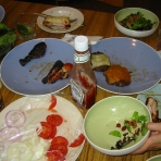 Remains of grilled chicken, burgers, and salad. Remains of grilled chicken, burgers, and salad.