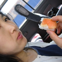 Mari eating Mari enjoys pickled salmon sushi on the bus.