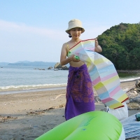 Mari on the beach Mari unfolds a plastic mat just big enough for two.